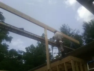 Carpenter setting a ridge beam over a new addition frame — Ice Dam Removal by Roofing Brothers in Amboy
