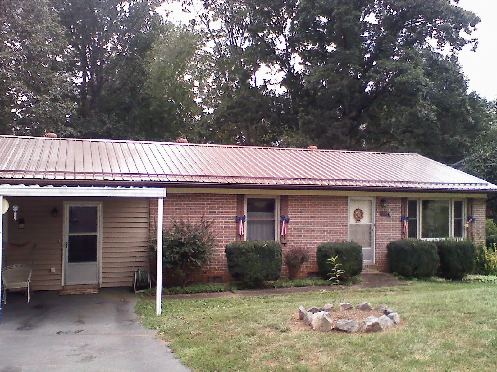 Bronze metal roof and carport on a brick ranch home — Roof Repair work by our crew in Amboy